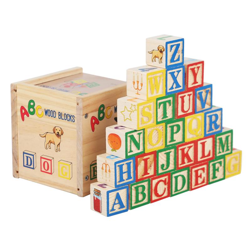 Alphabet blocks stacked beside wooden storage box